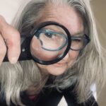 Photo of Holly looking through a magnifying glass